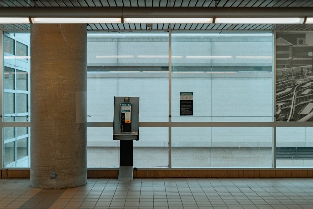 a parking meter in front of a large window