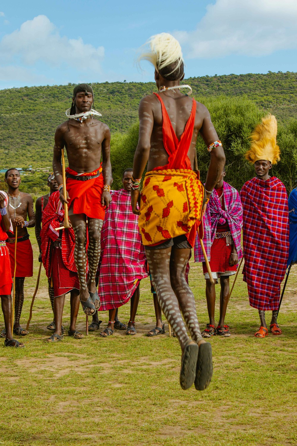 a group of people standing on top of a lush green field