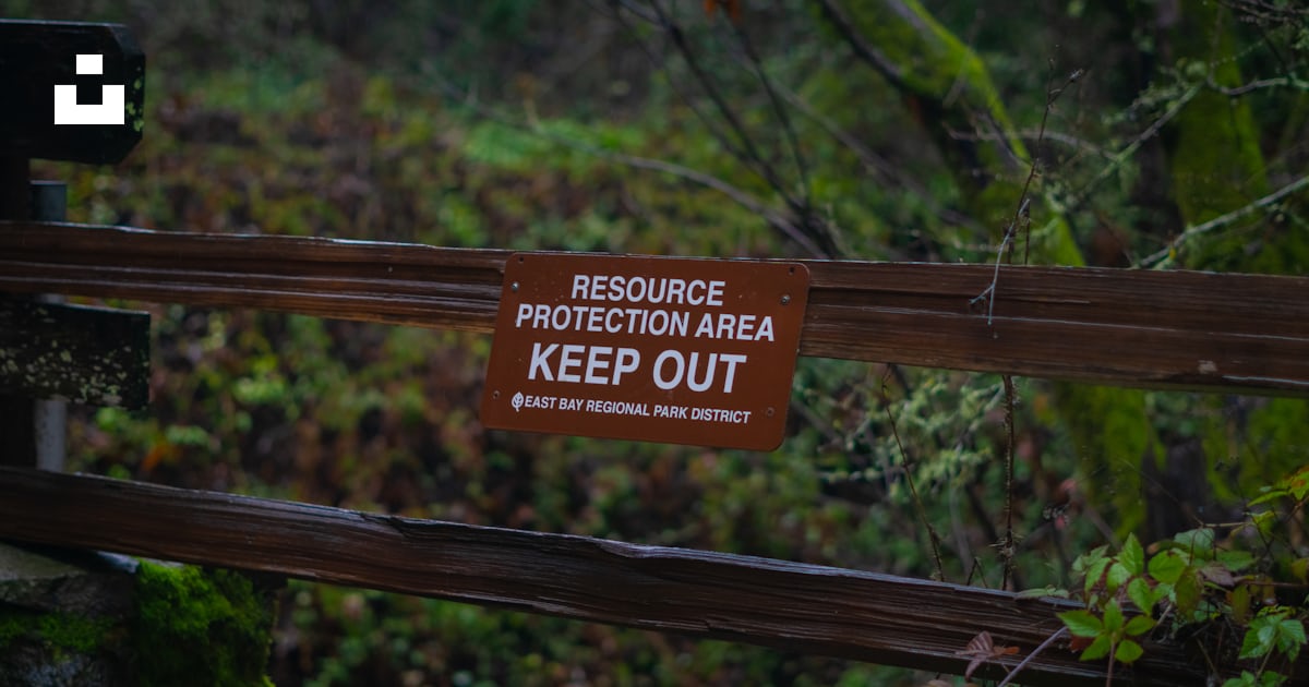 A wooden fence with a sign on it that says, resources protection area ...