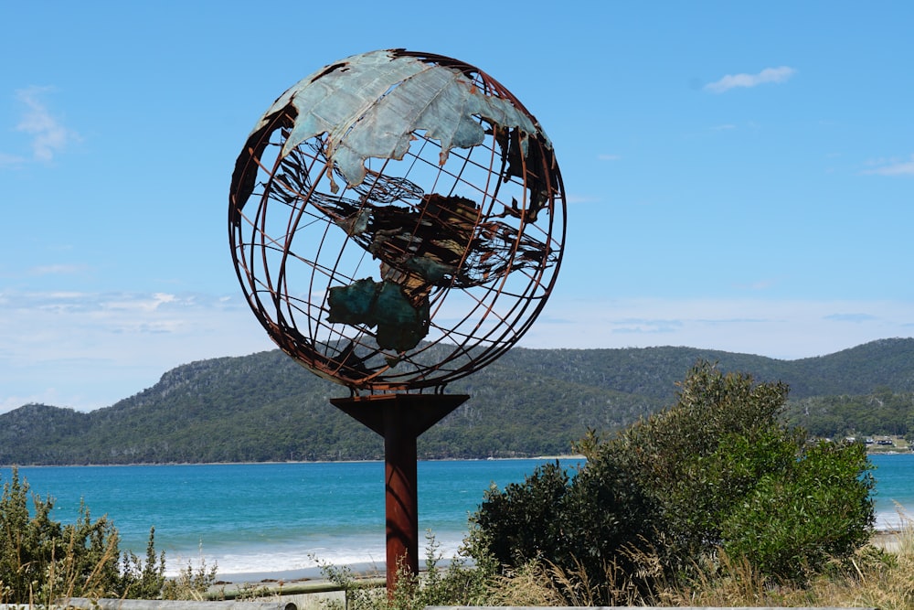 a large metal globe sitting on top of a metal pole