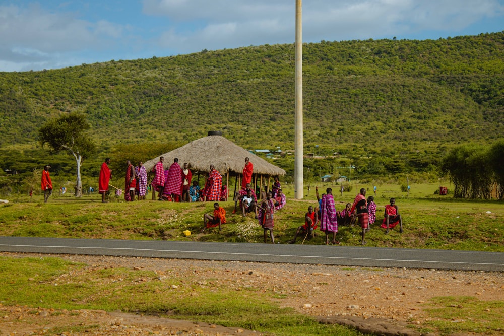 a group of people standing in front of a hut