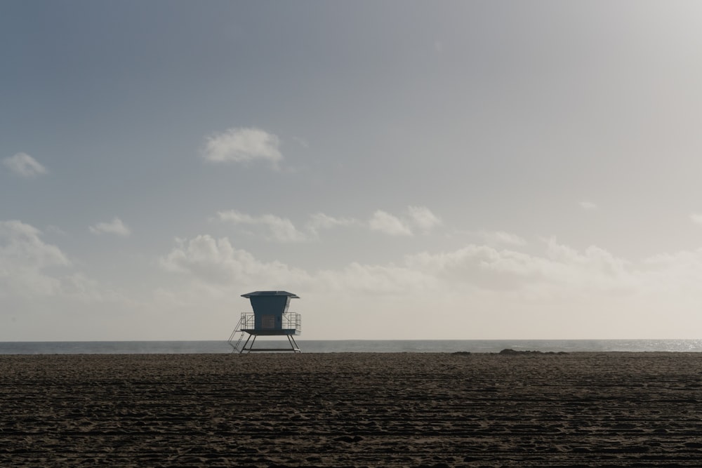 a lifeguard chair sitting on top of a sandy beach