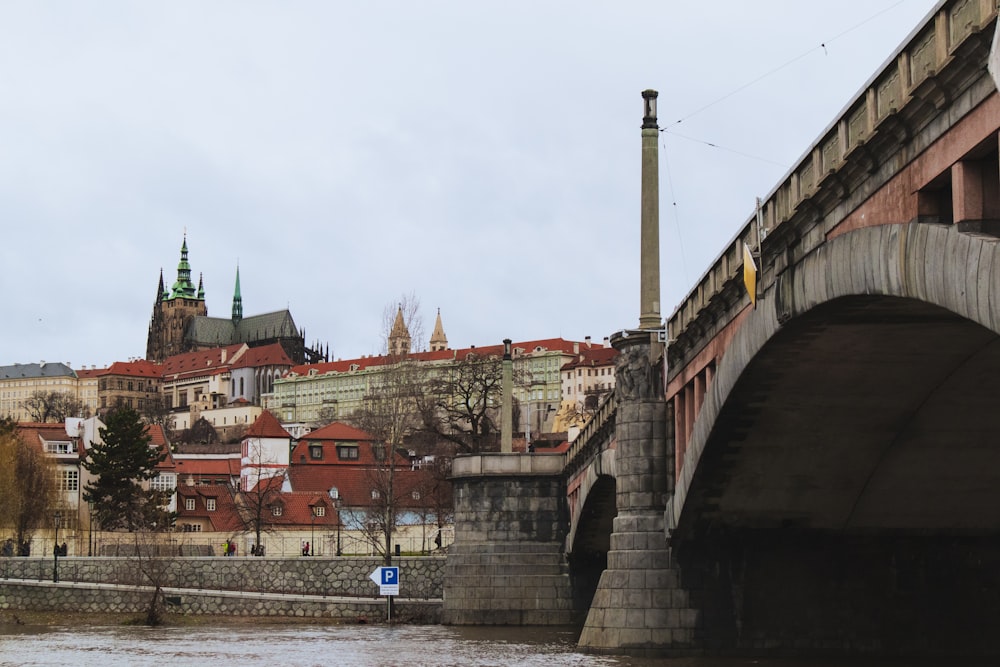 a bridge over a body of water with buildings in the background