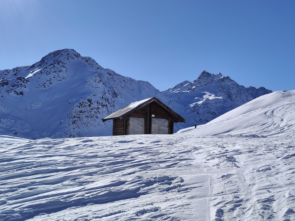 a small cabin in the middle of a snowy mountain