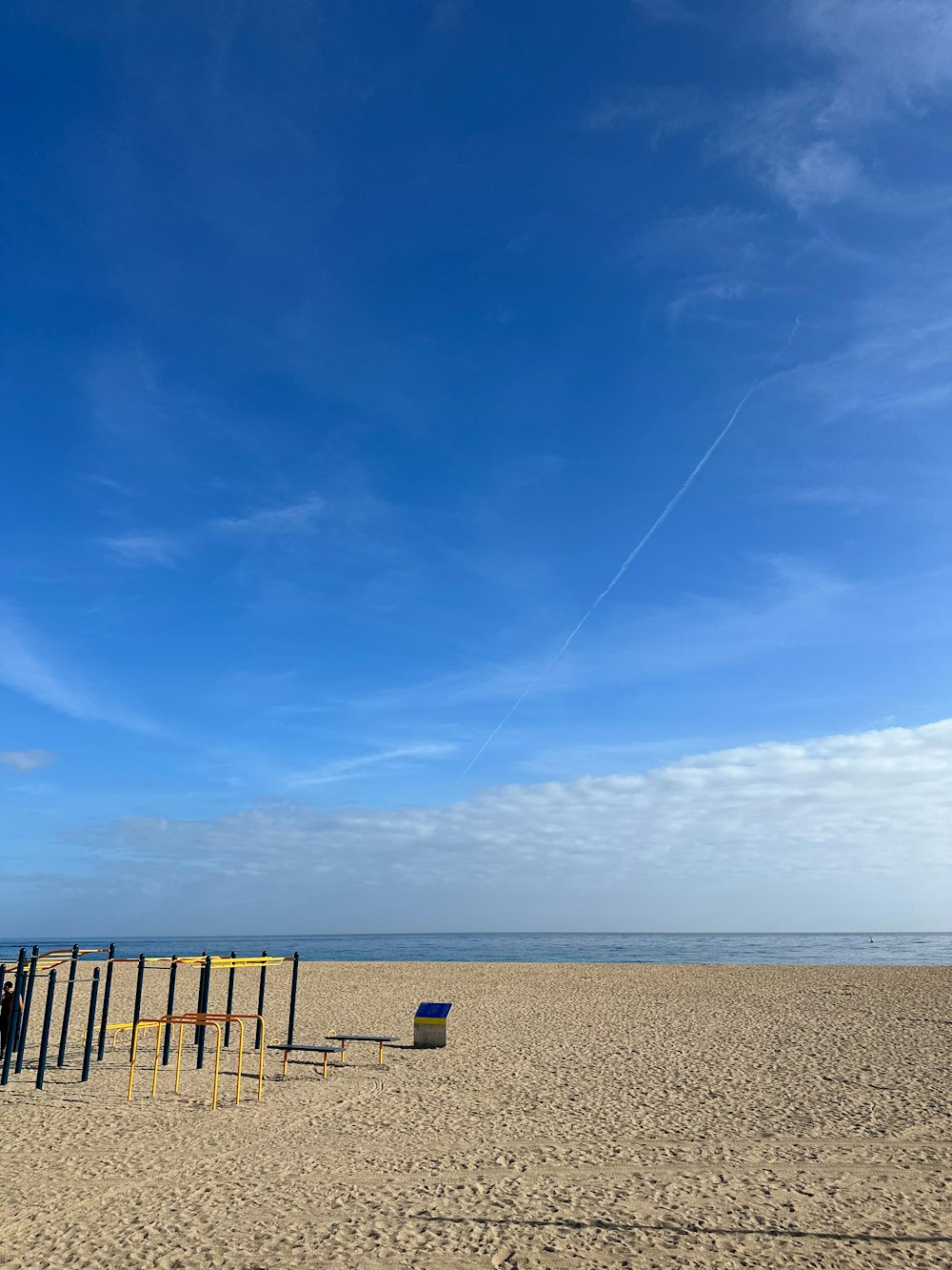 a kite flying in the sky over a sandy beach