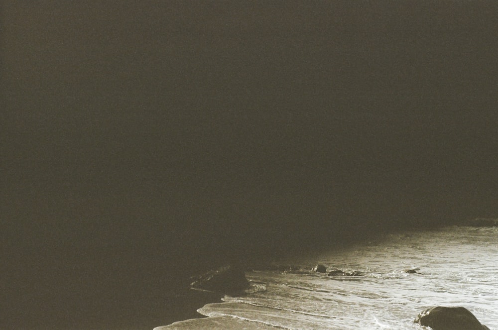 a person standing on a beach with a surfboard