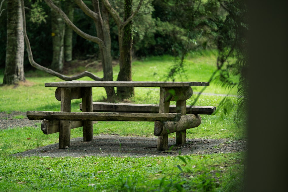 a wooden bench sitting on top of a lush green field