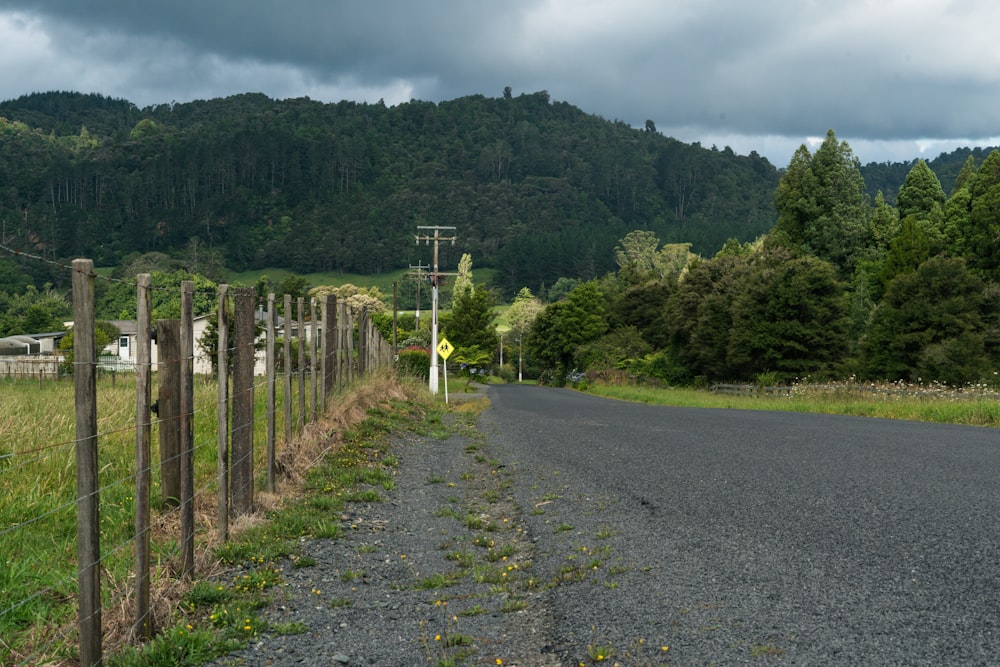 a rural road surrounded by a forest and mountains