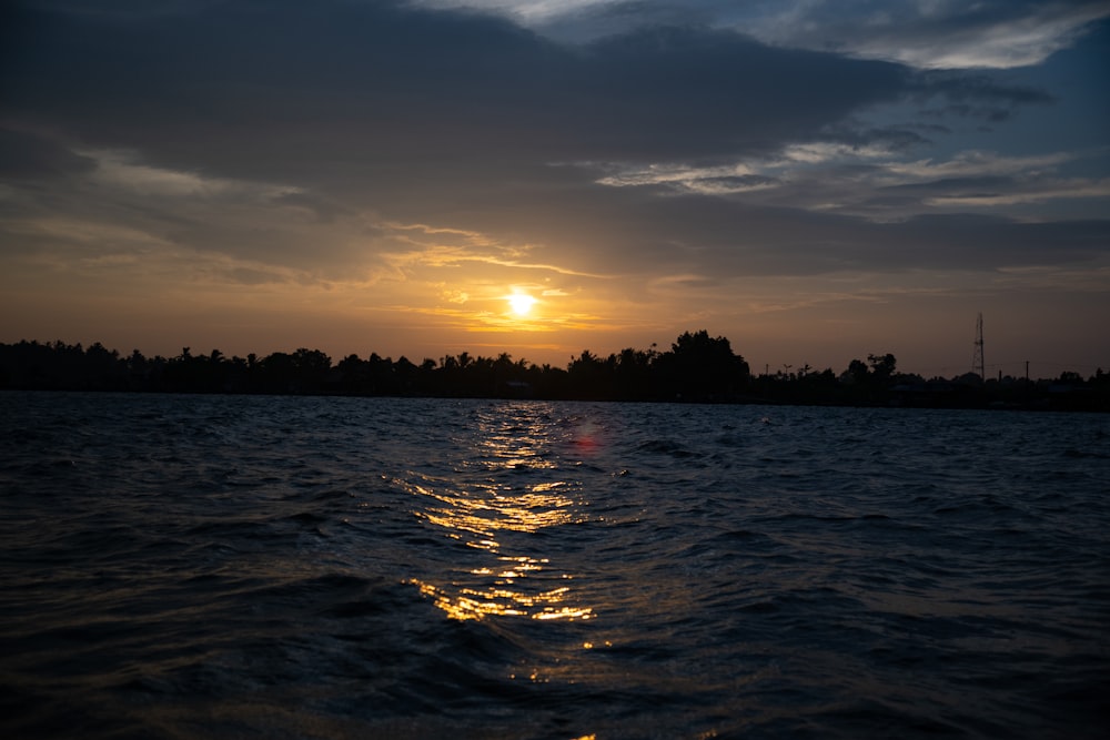 the sun is setting over a body of water