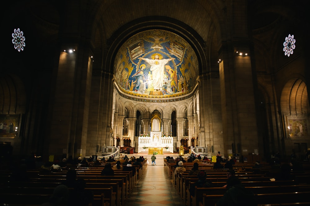 a church filled with lots of pews and a large stained glass window