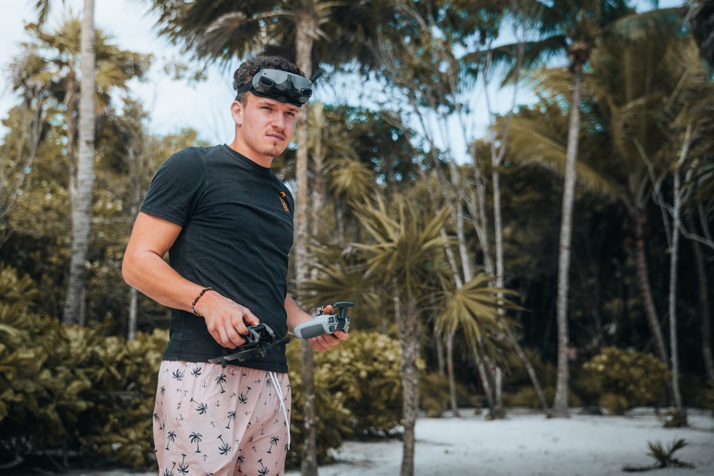 a man standing in front of a forest holding a camera