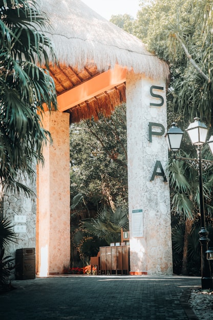 the entrance to a tropical resort with a thatched roof