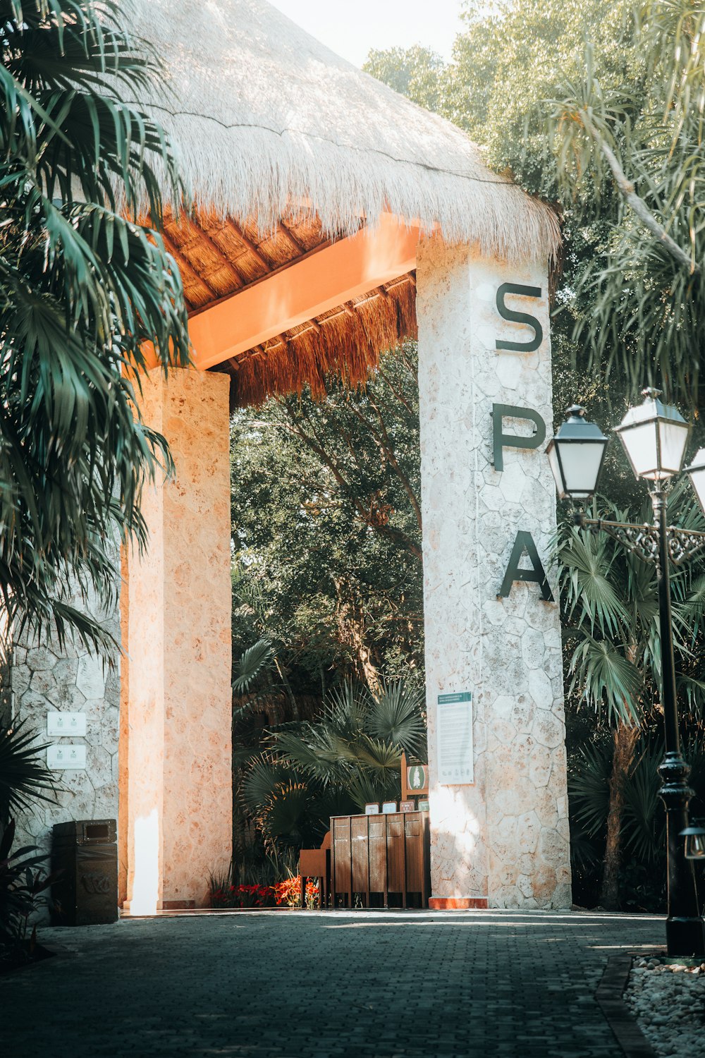 the entrance to a tropical resort with a thatched roof