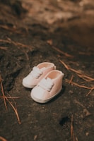 a pair of white shoes sitting on top of a rock