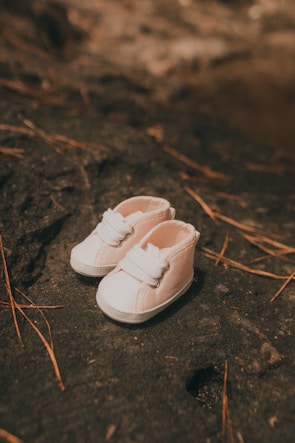 a pair of white shoes sitting on top of a rock