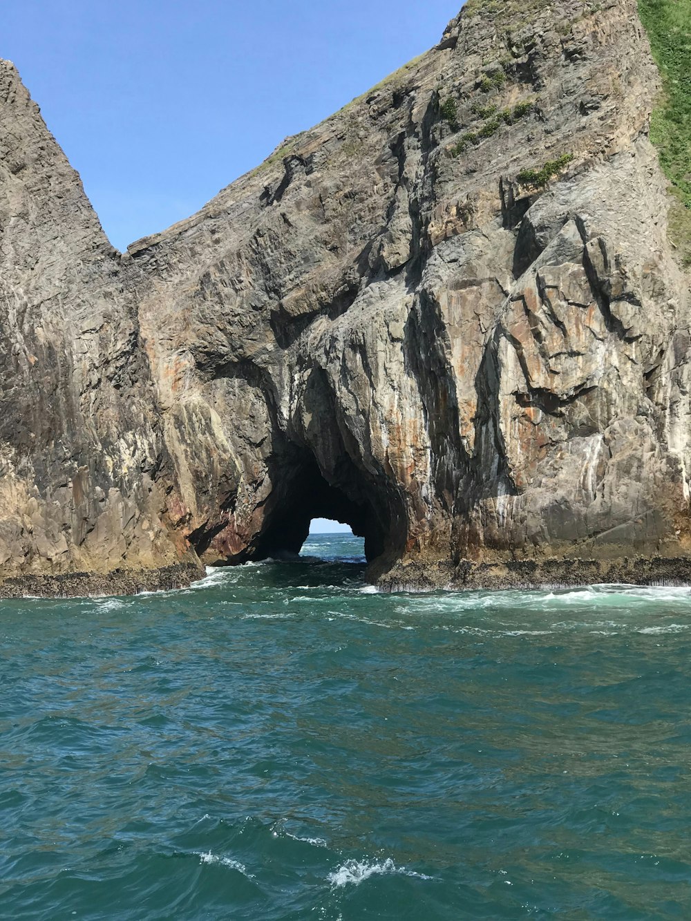 a large rock formation in the middle of a body of water