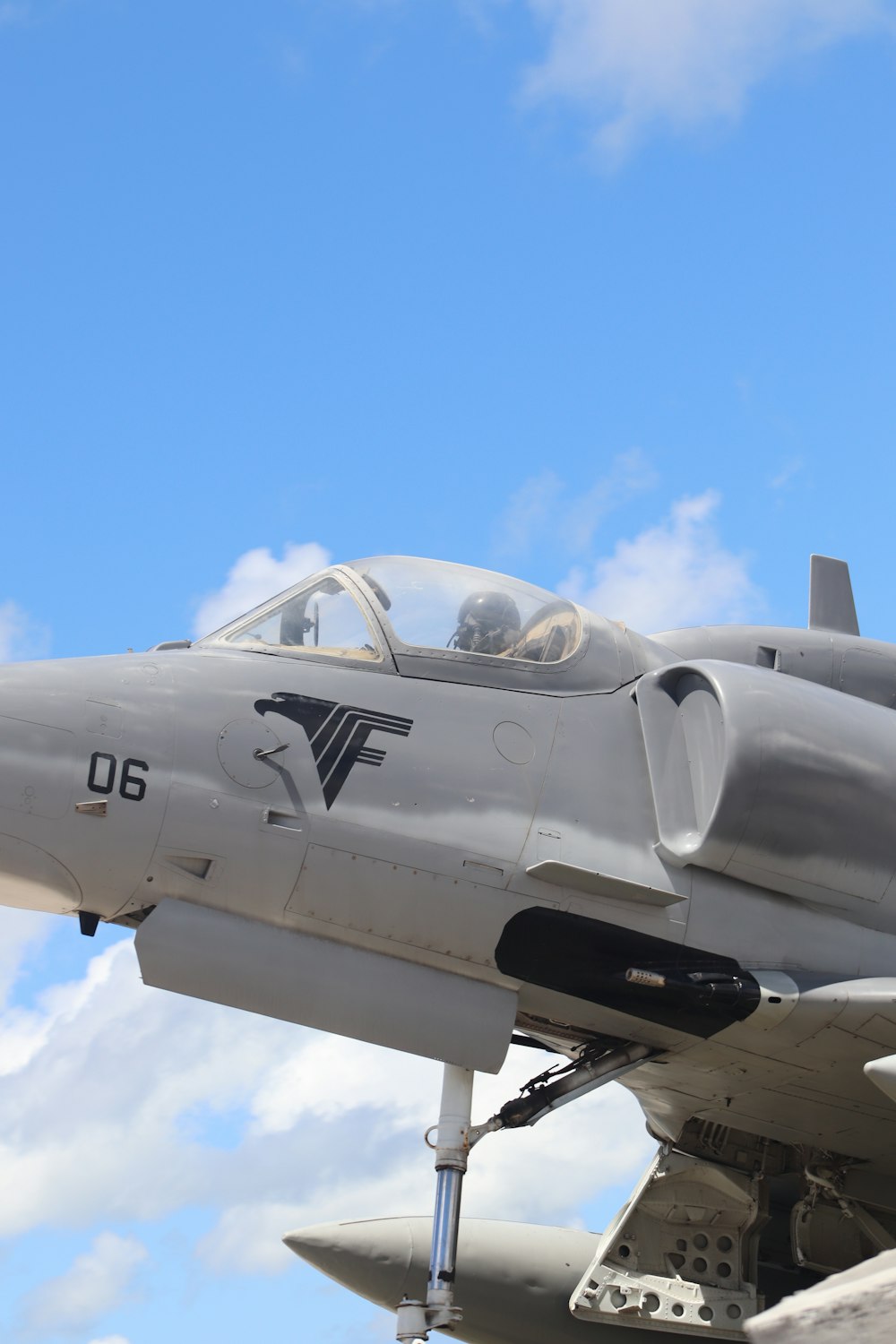 a fighter jet flying through a cloudy blue sky