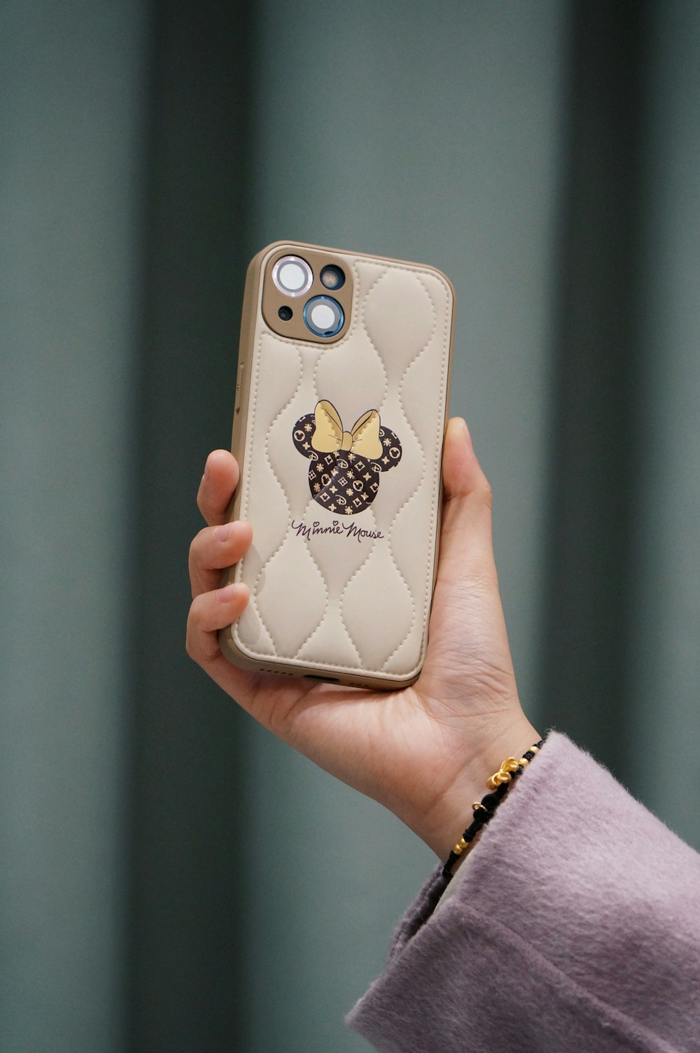 a person holding a cell phone with a mickey mouse design on it