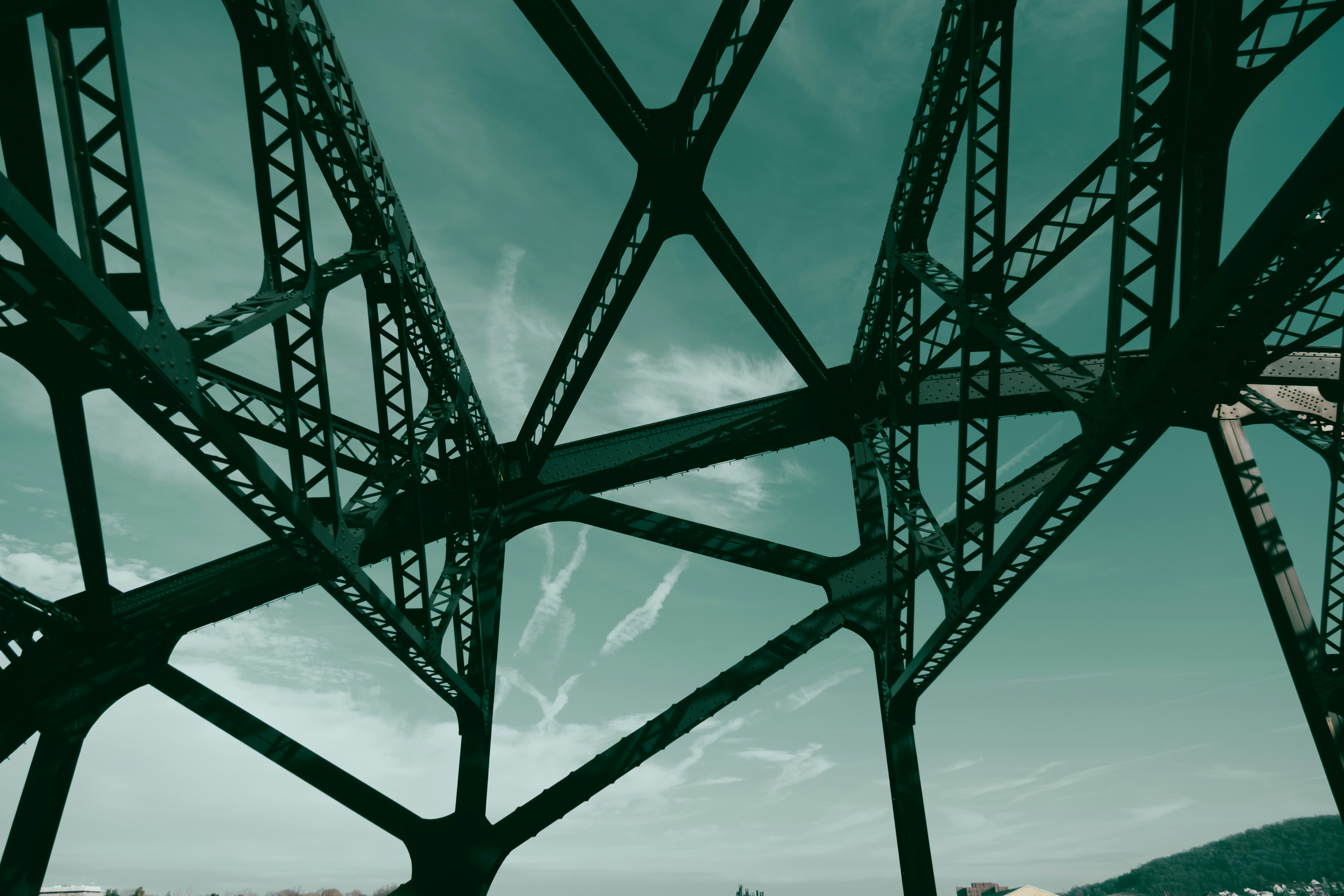 the underside of a metal structure with a sky background