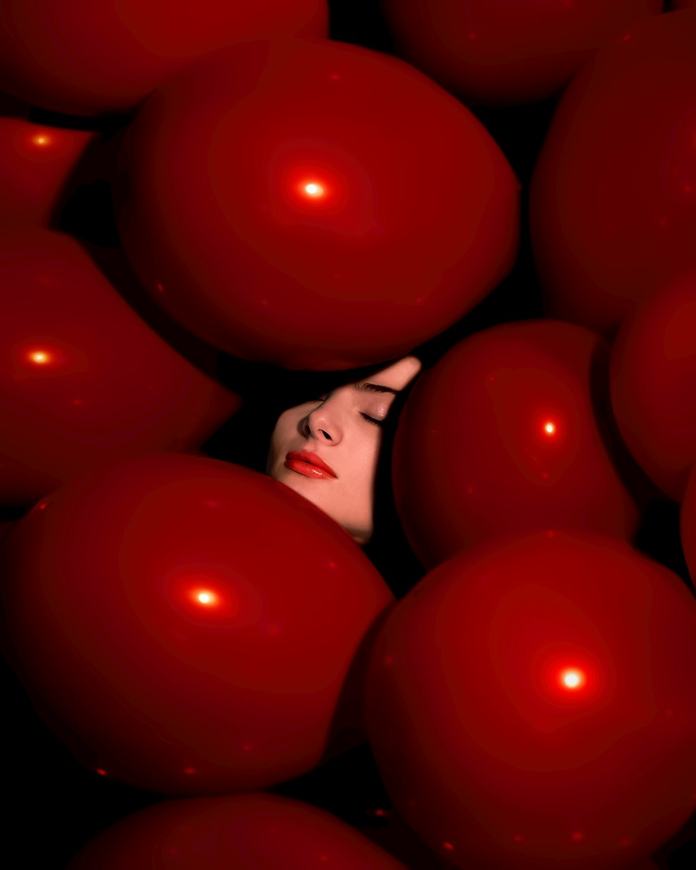 a woman is surrounded by red balls