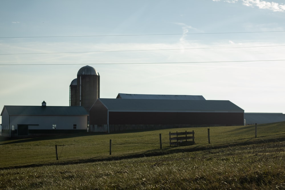 a farm with a barn and silo in the background