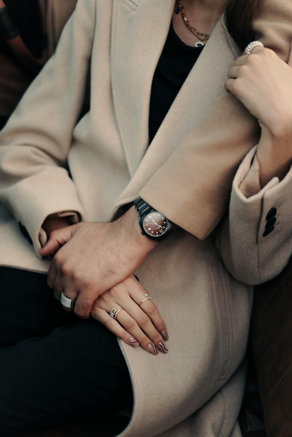 a woman in a beige coat sitting down