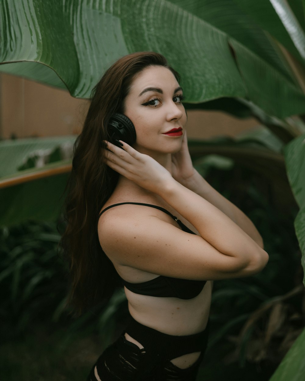 a woman with long hair wearing a bra and holding a cell phone to her ear