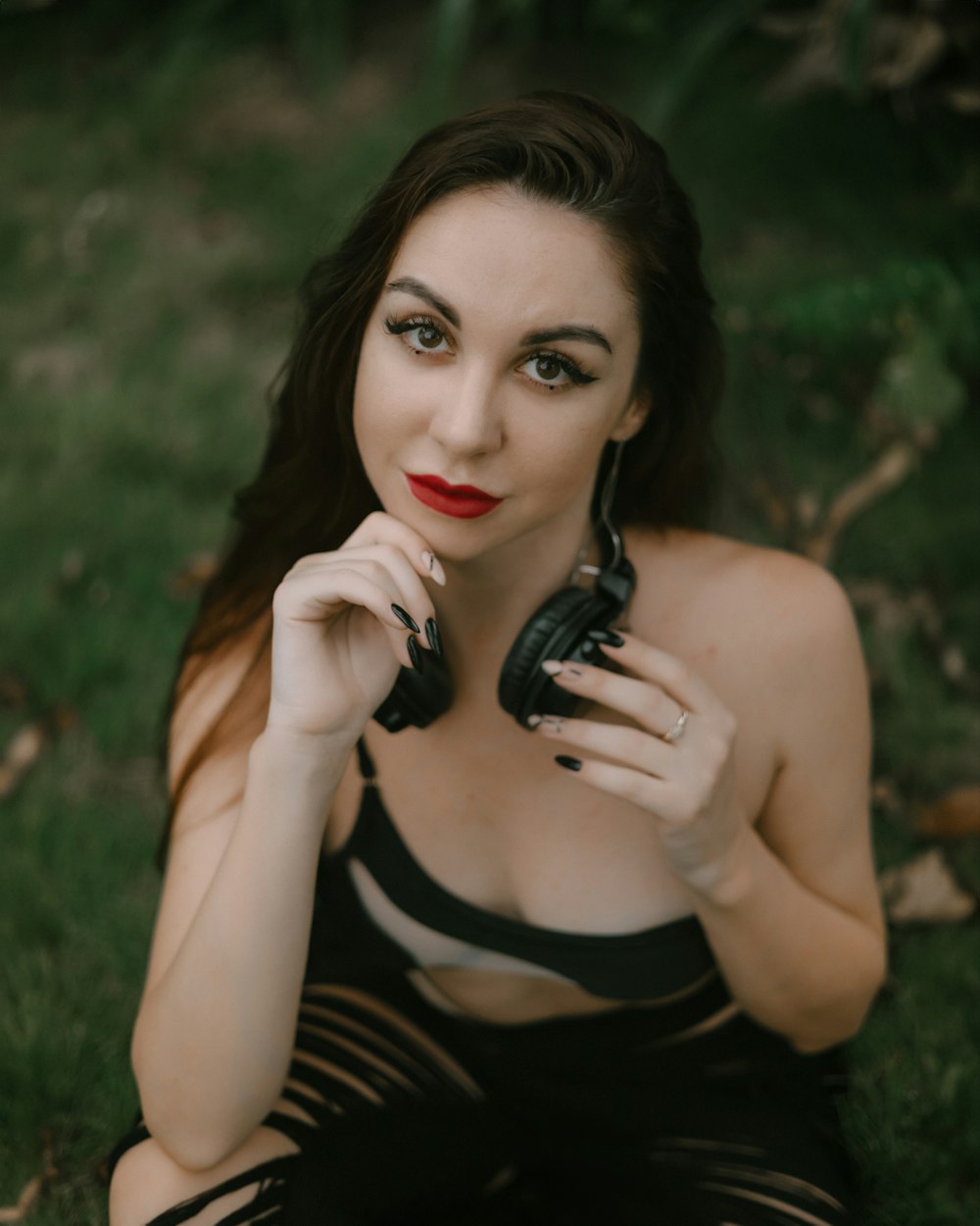 a woman sitting in the grass holding a cell phone