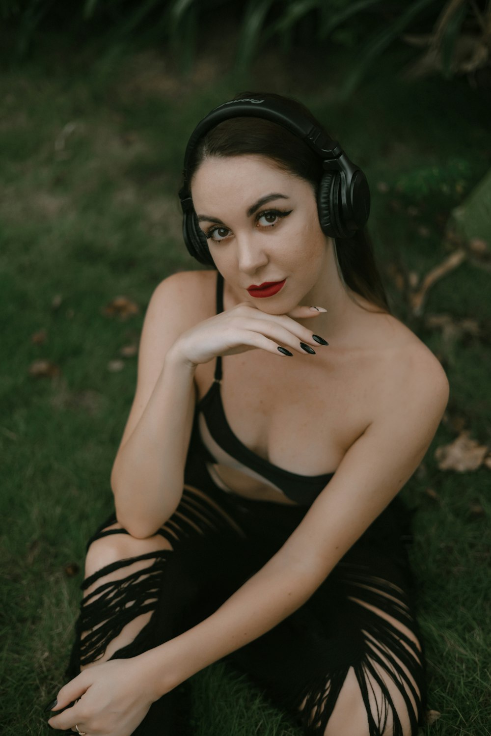 a woman wearing headphones sitting in the grass