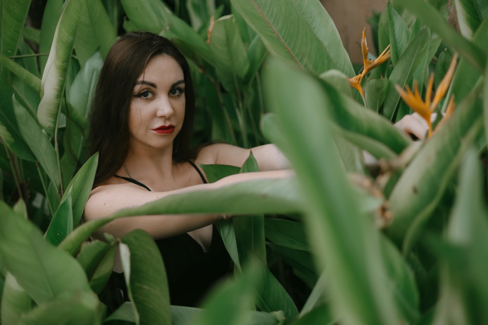 a woman is sitting in a field of green plants