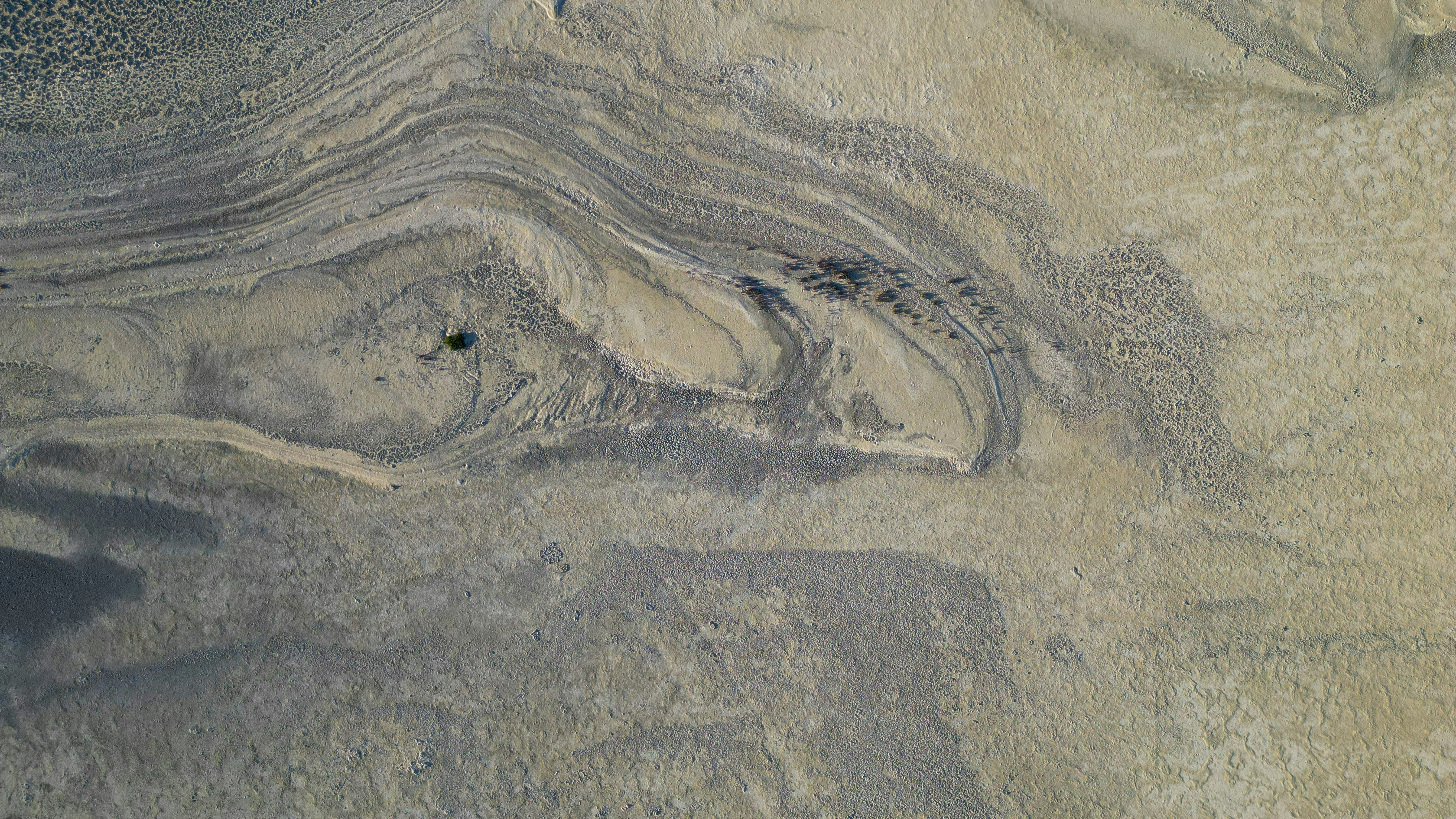 an aerial view of a desert area with sand and water