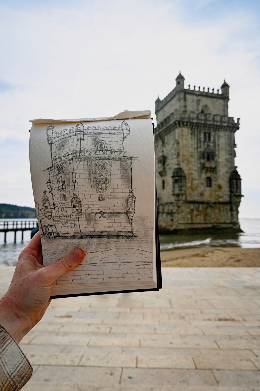 a person holding up a drawing of a castle