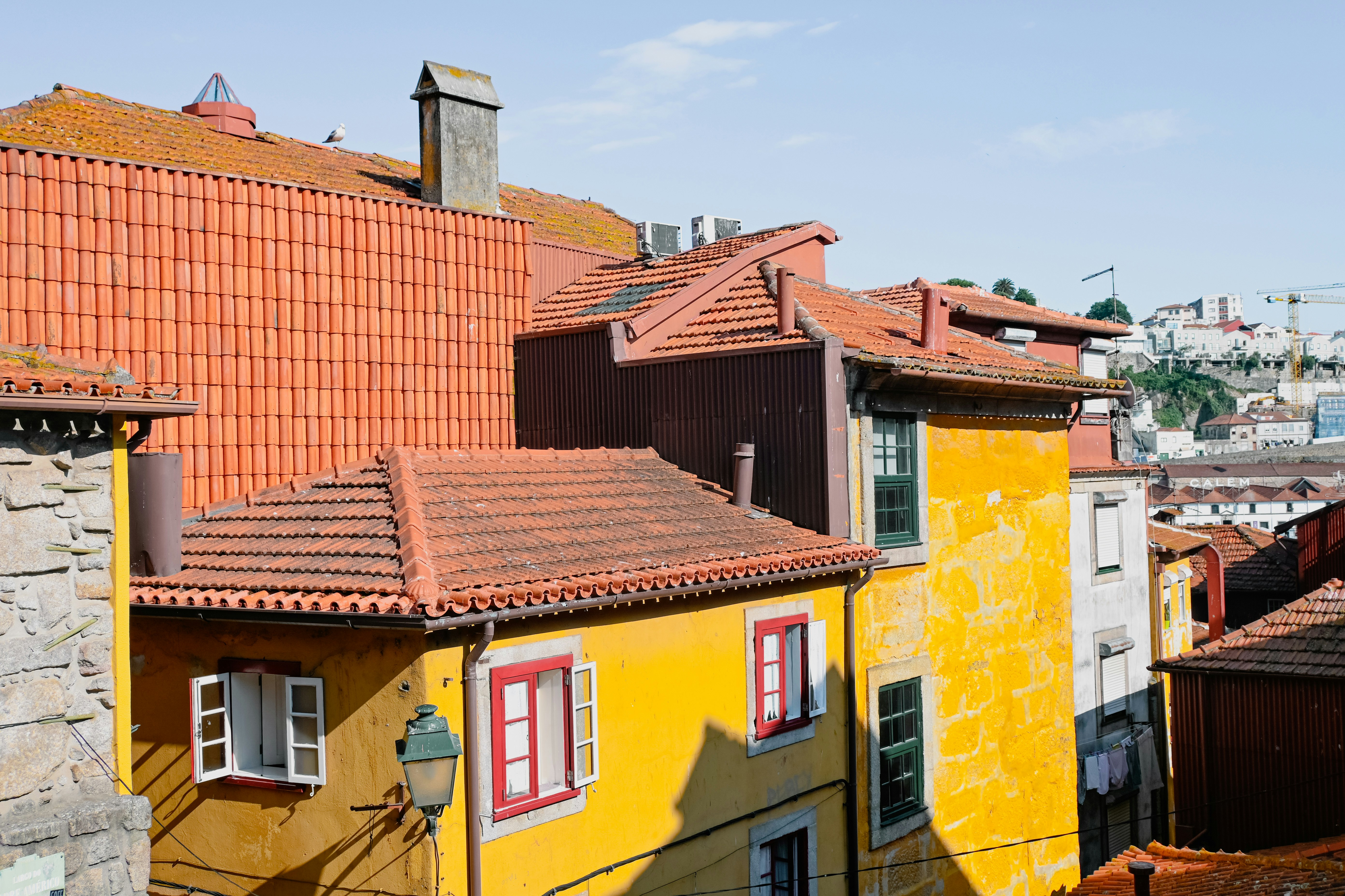 Un edificio giallo con il tetto rosso e le persiane rosse