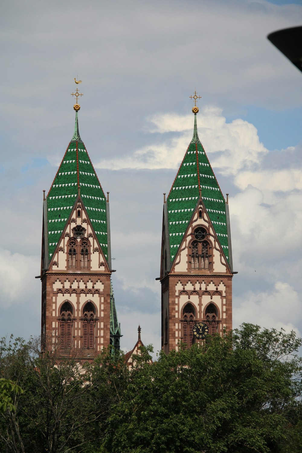 two towers of a building with a green roof