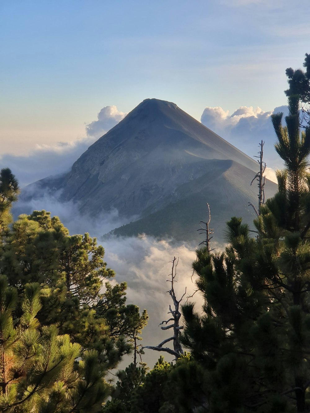 a view of the top of a mountain in the clouds