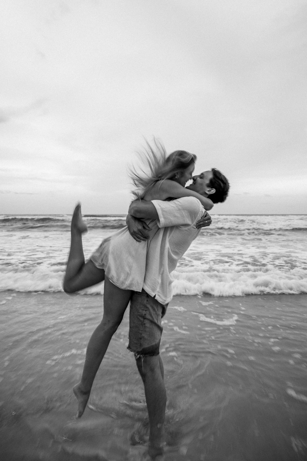 a man carrying a woman on his back on the beach