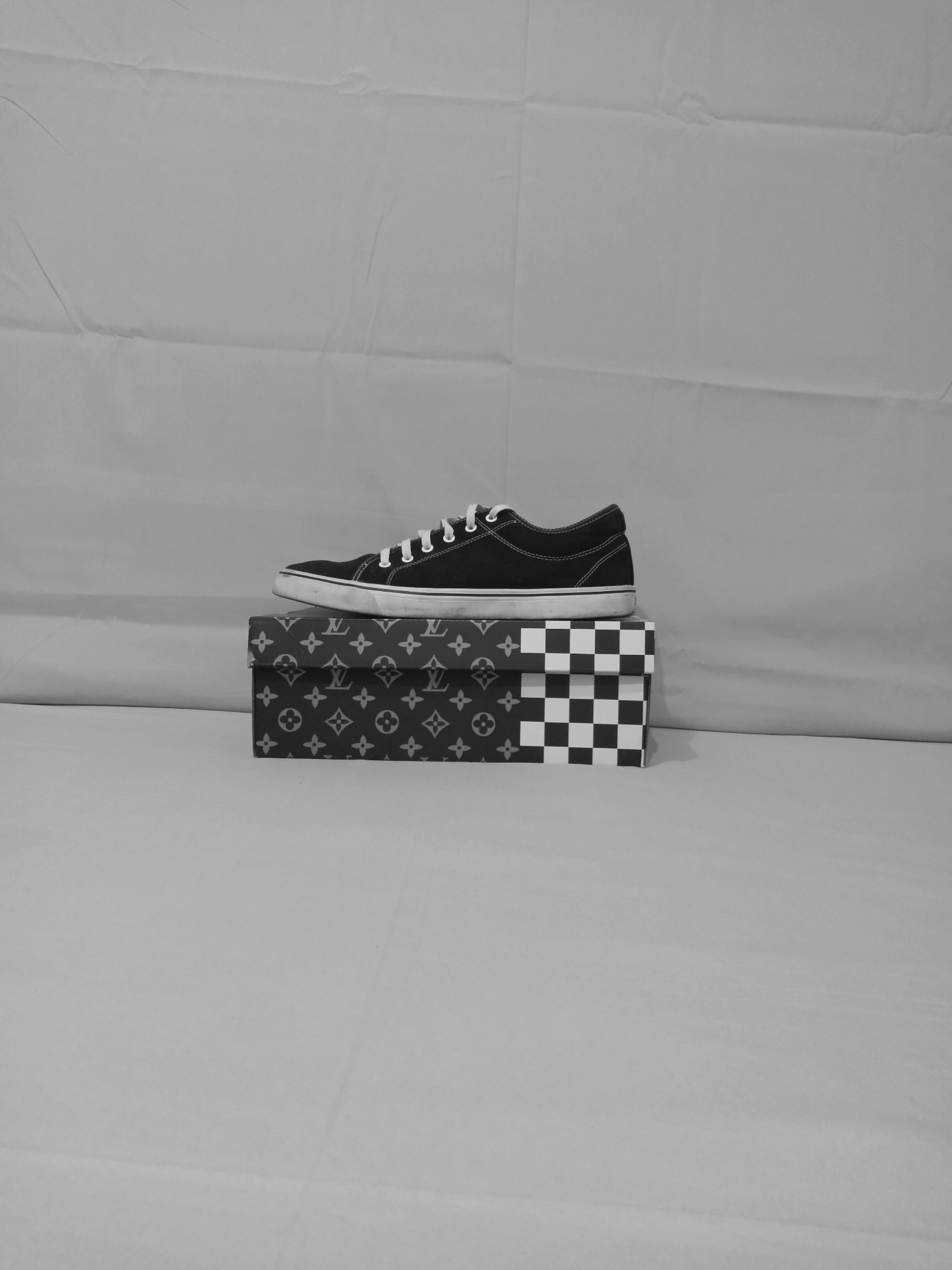 Bright clean studio with white sneaker on minimalist white pedestal, soft even studio lighting