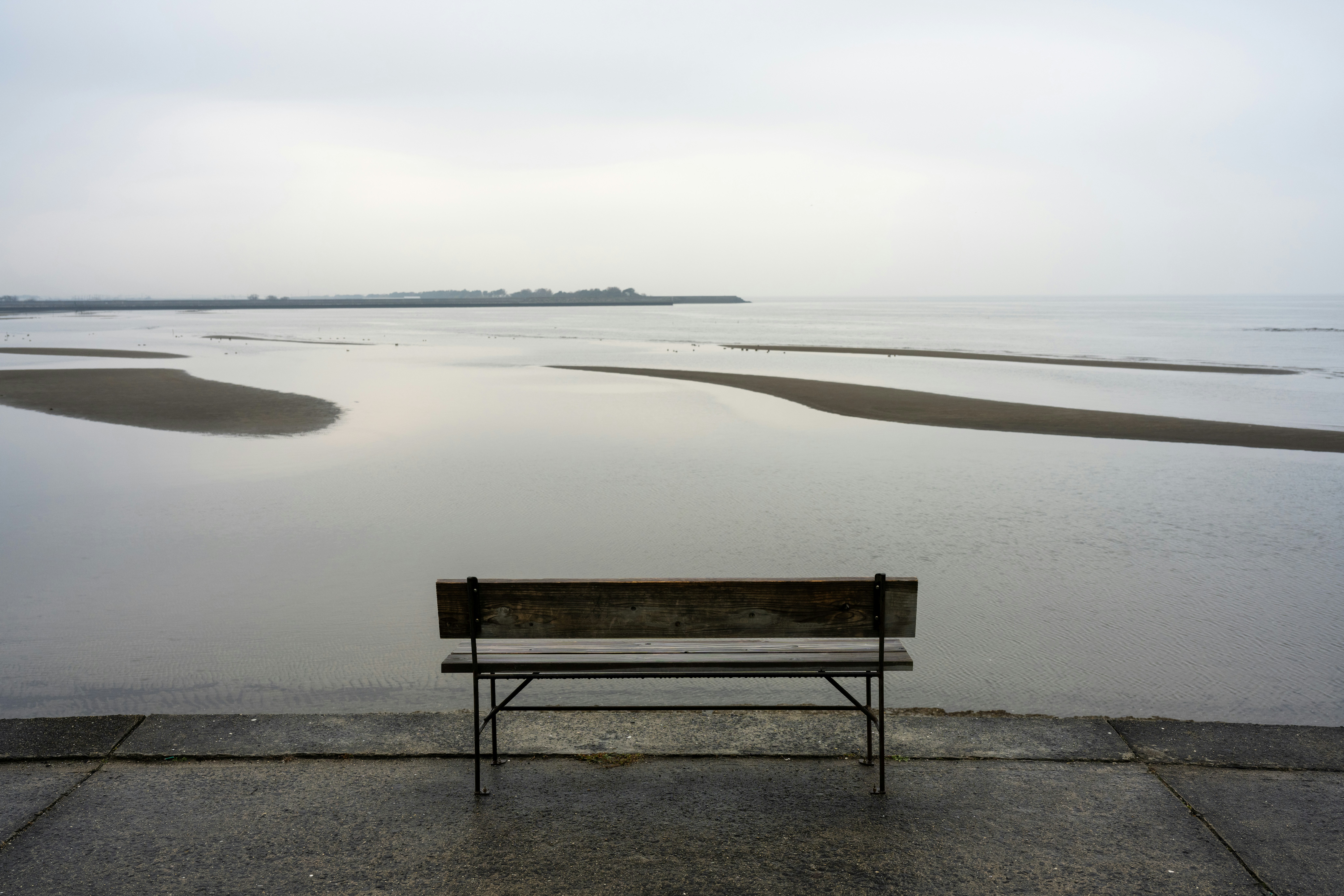 A bench sitting next to a body of water photo – Free Grey Image on Unsplash