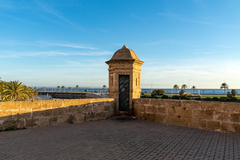 a clock tower sitting on top of a stone wall