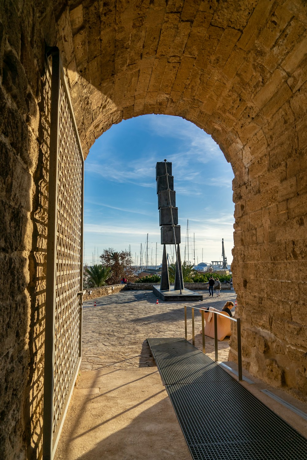 a stone arch with a bench in front of it