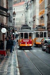 a red and yellow trolley on a city street