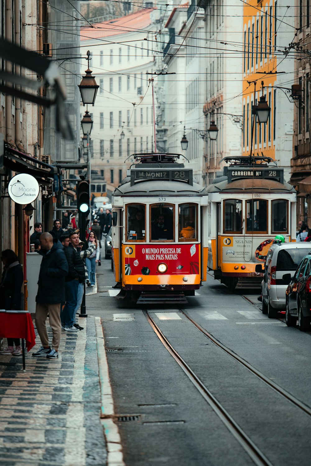 a red and yellow trolley on a city street