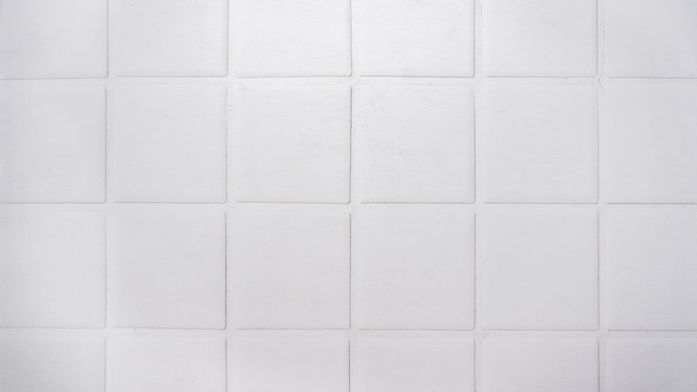 a black and white photo of a white tiled wall