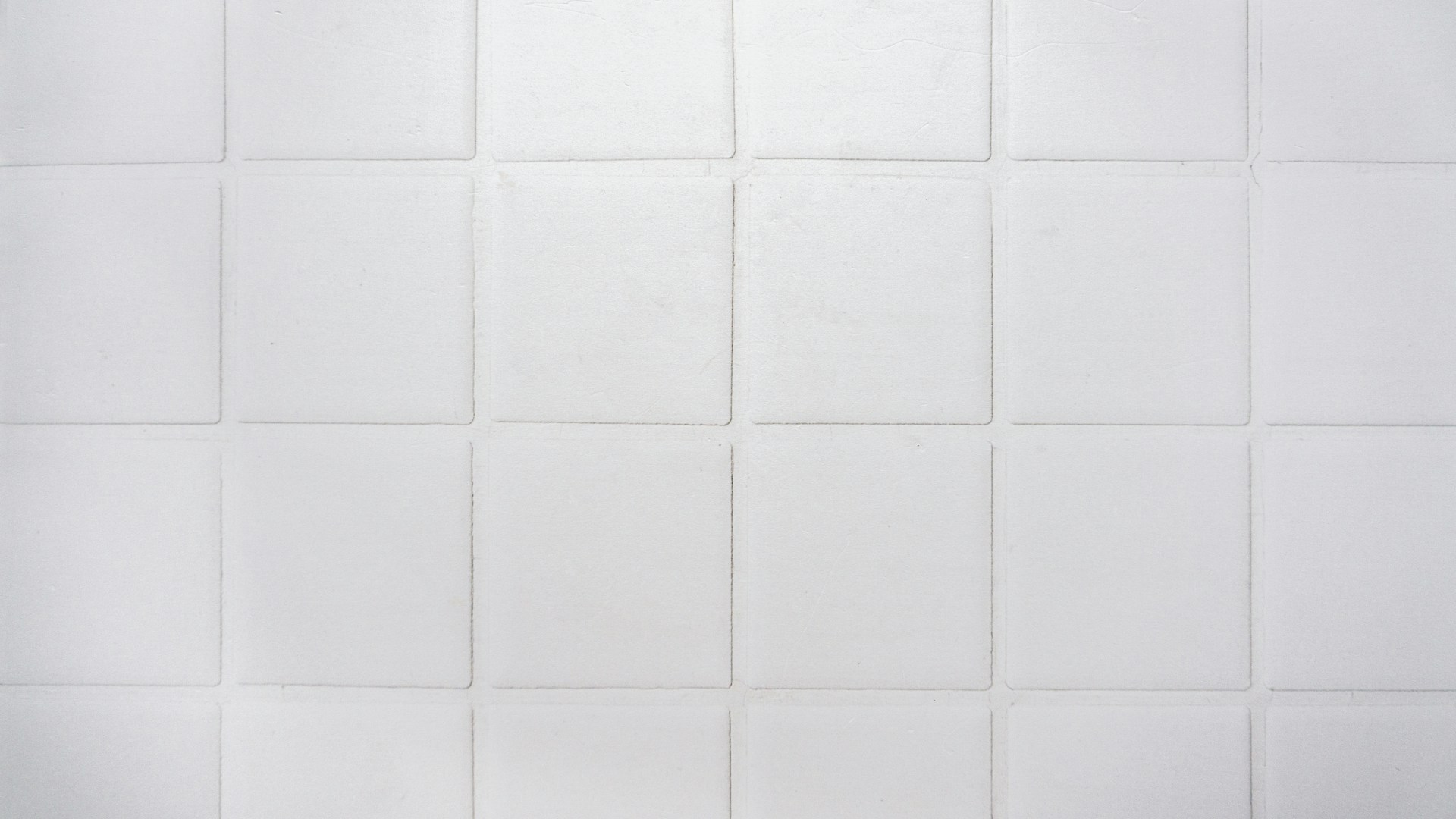 a black and white photo of a white tiled wall