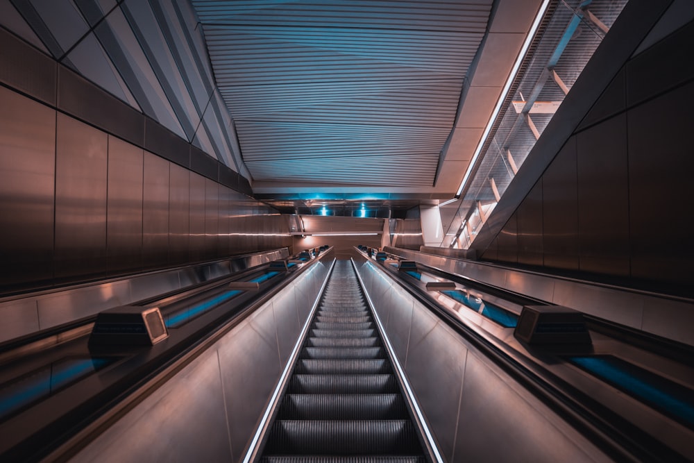 an escalator in a subway station with blue lights
