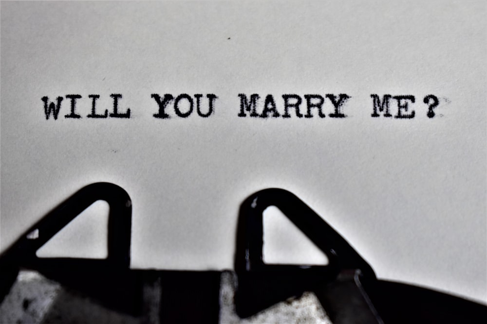a close up of a typewriter with the words will you marry me?