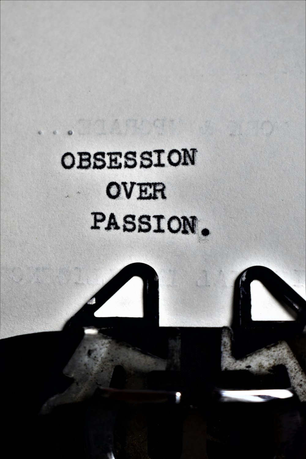 una máquina de escribir con las palabras obsesión por encima de la pasión escritas en ella