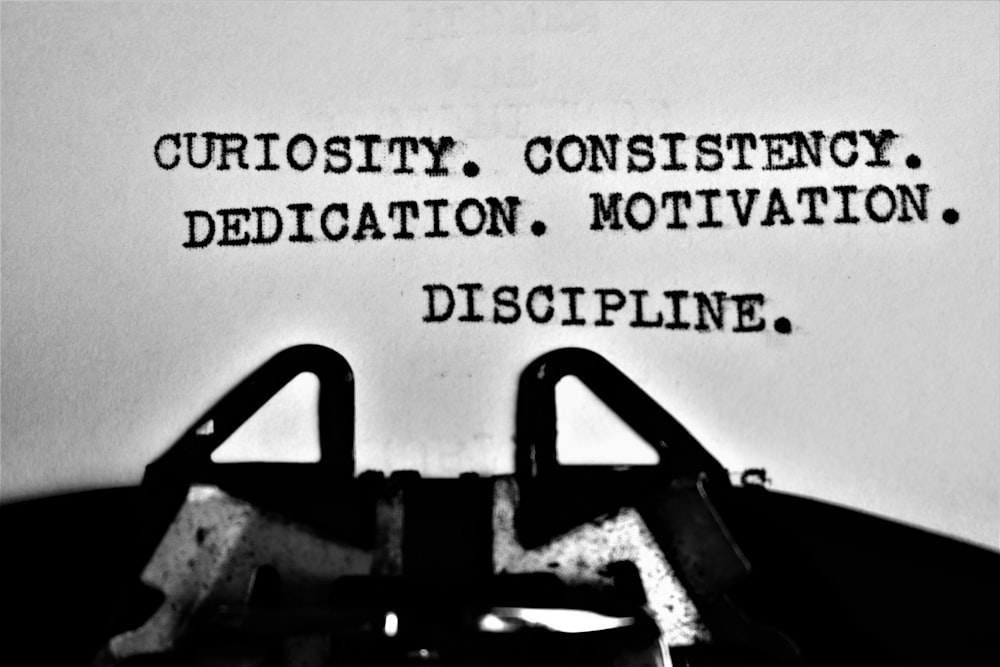 a typewriter with the words curiosity, consisting of dedication, motivation, and di
