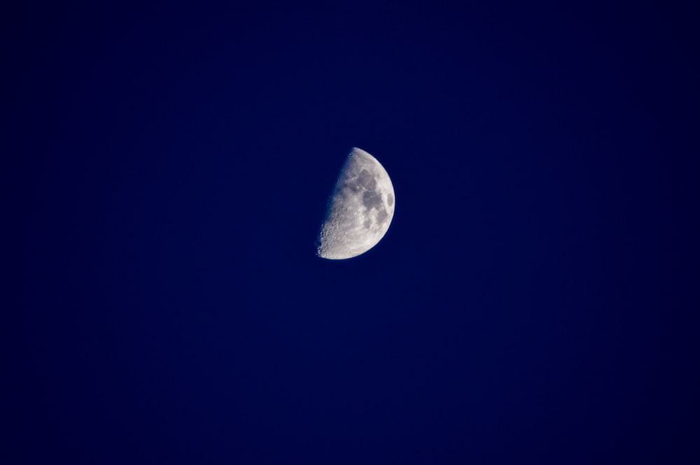 a half moon in a dark blue sky