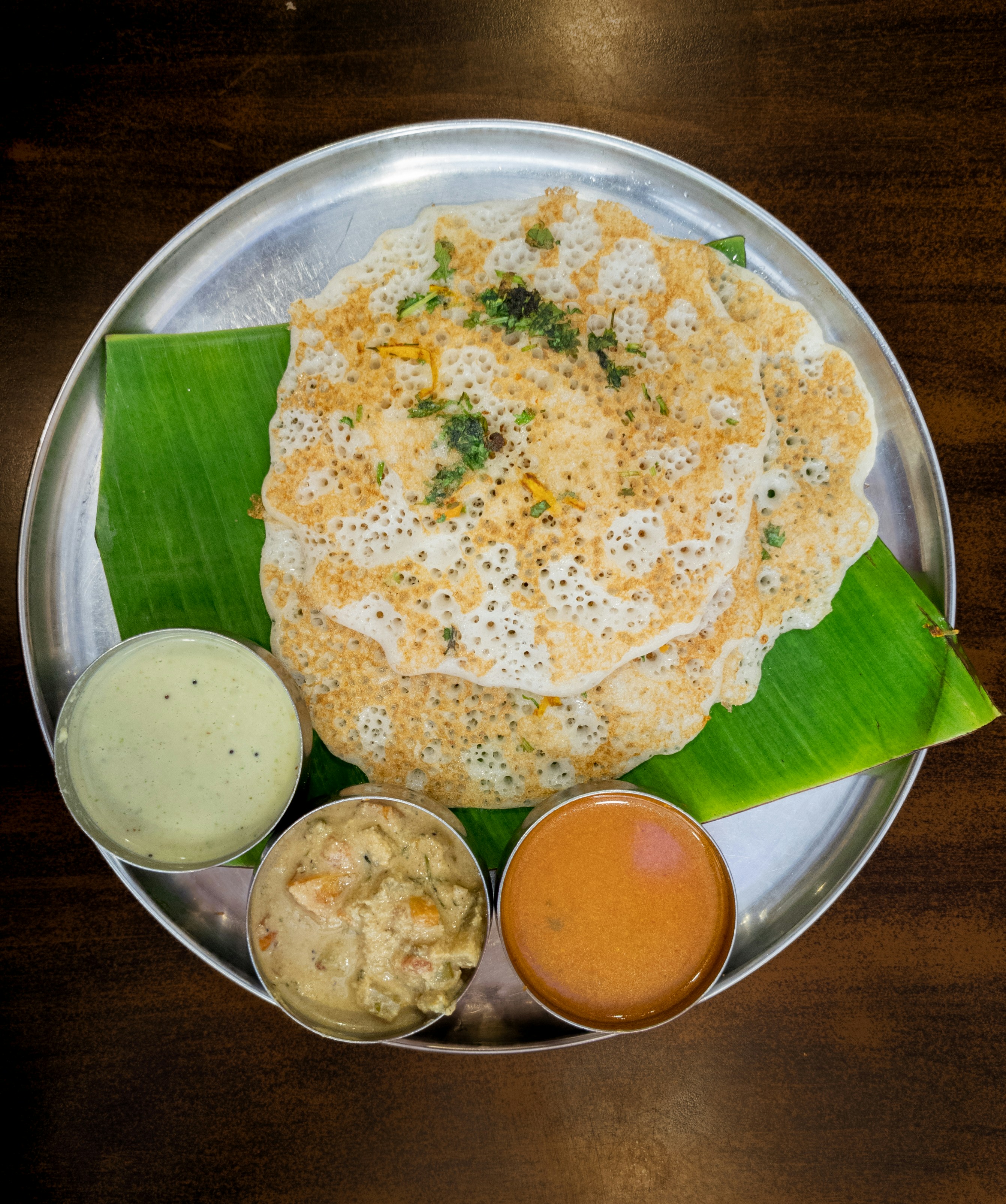 South Indian dosa served on a banana leaf with chutneys and sambar